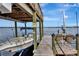 Dock view featuring a boat lift, chairs, and a boat, all with serene waterfront views at 434 S Beach St, Ormond Beach, FL 32174