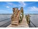 Picturesque dock featuring stairs leading to an upper deck, boat lift, and serene waterfront views at 434 S Beach St, Ormond Beach, FL 32174