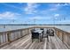 Waterfront deck furnished with table and chairs, and strung with decorative lighting providing beautiful water views at 434 S Beach St, Ormond Beach, FL 32174