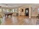 Spacious living room with pool table, hardwood floors, and lots of natural light from the multiple windows at 434 S Beach St, Ormond Beach, FL 32174