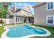 Backyard featuring a unique shaped pool, spa, covered porch, and lush synthetic grass at 4474 Enders St, Orlando, FL 32814