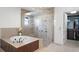 Luxurious bathroom featuring a glass enclosed shower, soaking tub, and access to the walk-in closet at 4474 Enders St, Orlando, FL 32814