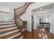 Elegant foyer featuring hardwood floors, a wooden staircase, and an open view into the living area at 4474 Enders St, Orlando, FL 32814
