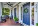 Inviting front porch with a blue door adorned with a wreath, flanked by sidelights and a bench at 4474 Enders St, Orlando, FL 32814