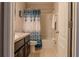Clean bathroom with a shower-tub combo, vanity, and white and blue shower curtain at 459 Millwood Pl, Winter Garden, FL 34787