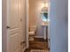 A compact half-bathroom featuring a toilet and pedestal sink, maximizing space in a minimalist design at 459 Millwood Pl, Winter Garden, FL 34787