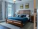 Tranquil bedroom with a wooden bed frame and a blue comforter with matching pillows at 459 Millwood Pl, Winter Garden, FL 34787