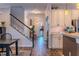 Inviting entryway with wood floors, staircase, and view into the kitchen provides a warm welcome at 459 Millwood Pl, Winter Garden, FL 34787