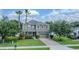 Charming two-story home featuring a manicured lawn, brick driveway, and mature landscaping, with solar panels on the roof at 459 Millwood Pl, Winter Garden, FL 34787