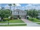 Charming two-story home featuring a manicured lawn, brick driveway, and mature landscaping at 459 Millwood Pl, Winter Garden, FL 34787