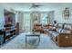 Spacious living room with a large brown leather sofa, modern ceiling fan, and plentiful natural light at 459 Millwood Pl, Winter Garden, FL 34787