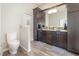Modern bathroom with dual sinks, dark wood cabinets, and stylish fixtures, including a toilet at 491 Freeman St, Longwood, FL 32750