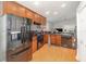 Well-lit kitchen with stainless steel refrigerator, wooden cabinets, and modern appliances at 491 Freeman St, Longwood, FL 32750