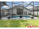 Backyard pool with screened enclosure surrounded by green grass and patio furniture at 491 Freeman St, Longwood, FL 32750