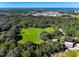 Aerial view showcasing a large green lawn, surrounded by trees, and with a barn and other buildings on the property at 550 Orient Ave, Debary, FL 32713