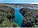 Aerial view of a waterway with a dock, surrounded by lush trees and vegetation, leading out to a body of water at 550 Orient Ave, Debary, FL 32713