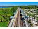 Aerial view of train tracks leading into a station, surrounded by trees and green space with a water view at 550 Orient Ave, Debary, FL 32713