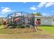 A spacious backyard with a screened-in patio, lush lawn, and vibrant landscaping at 570 Cascading Creek Ln, Winter Garden, FL 34787