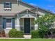 Close-up of a charming home entrance featuring lush landscaping, a welcoming wreath, and beautiful accent shutters at 570 Cascading Creek Ln, Winter Garden, FL 34787