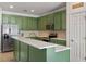 Bright kitchen with an island featuring quartz countertops, stainless steel appliances and green-painted cabinetry at 570 Cascading Creek Ln, Winter Garden, FL 34787