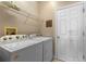 Well-lit laundry room features a Whirlpool washer and dryer, shelving, and a laundry-themed decor sign at 570 Cascading Creek Ln, Winter Garden, FL 34787