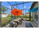 Relaxing screened patio with comfortable seating and dining table surrounded by lush landscaping at 570 Cascading Creek Ln, Winter Garden, FL 34787