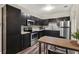 Modern kitchen with stainless steel appliances, granite countertops, and dark cabinets at 600 Bostwick Ave, Daytona Beach, FL 32118