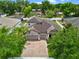 Two-story home with three-car garage, a brick driveway, and a charming landscaped yard surrounded by mature trees at 604 Fosters Grove Loop, Oviedo, FL 32765