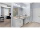 Bathroom featuring dual sinks, a large mirror with lights, and an open view into the main bedroom at 604 Fosters Grove Loop, Oviedo, FL 32765