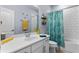Bright bathroom with a single sink vanity, white subway tile, and fun shower curtain at 604 Fosters Grove Loop, Oviedo, FL 32765
