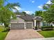 Charming two-story home featuring a three-car garage, brick driveway, and beautifully landscaped front yard at 604 Fosters Grove Loop, Oviedo, FL 32765