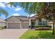 Charming home featuring a three-car garage, blue shutters, landscaped yard, and brick paver driveway at 604 Fosters Grove Loop, Oviedo, FL 32765