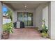 Covered patio with brick floor, potted plants, and an outdoor grill at 604 Fosters Grove Loop, Oviedo, FL 32765