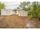 A spacious backyard with two storage sheds and a mix of greenery, offering ample storage and outdoor space at 6354 Hill Rd, Orlando, FL 32810