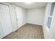Bedroom featuring wood-look flooring, double door closet, and a window providing natural light at 6354 Hill Rd, Orlando, FL 32810