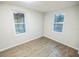 Bright bedroom featuring wood-look flooring and two windows providing natural light at 6354 Hill Rd, Orlando, FL 32810