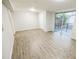 Living room with wood-look flooring, closet, and access to the deck with sliding glass doors at 6354 Hill Rd, Orlando, FL 32810