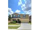 Inviting two-story home with a spacious driveway, beautiful lawn and vibrant blue window shutters at 651 Taft Dr, Davenport, FL 33837