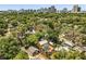 Aerial view of a neighborhood with lush trees and houses with the city skyline in the background at 706 Hillcrest St, Orlando, FL 32803