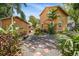 Backyard view displaying a home with a detached garage, mature trees, brick patio and outdoor seating at 706 Hillcrest St, Orlando, FL 32803
