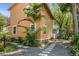Exterior view of a yellow home featuring well-maintained landscaping, a stepping stone path, and mature trees for privacy at 706 Hillcrest St, Orlando, FL 32803