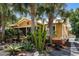 Charming yellow home featuring mature palms, a landscaped front yard, and a welcoming screened-in front porch entrance at 706 Hillcrest St, Orlando, FL 32803