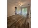 Open living area features wood-look flooring, ceiling fan, and balcony access at 7147 Yacht Basin # 132, Orlando, FL 32835