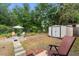 Spacious backyard featuring lush greenery, a storage shed, and a cozy outdoor seating area at 7951 Chediston Cir, Orlando, FL 32817