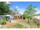 Backyard with a shed, seating area, manicured garden, and partially fenced at 7951 Chediston Cir, Orlando, FL 32817