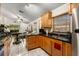 Open kitchen with stainless steel appliances, wooden cabinets, and tile flooring at 7951 Chediston Cir, Orlando, FL 32817