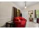 Cozy sitting room with red couch and accents, and tiled floors at 7951 Chediston Cir, Orlando, FL 32817