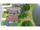 Aerial view of homes with screened-in pools, overlooking a tranquil lake surrounded by lush greenery at 842 Bentley Green Cir, Winter Springs, FL 32708