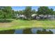 Spacious backyard with a pond, screened in patios, and lush green grass at 842 Bentley Green Cir, Winter Springs, FL 32708