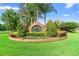 Beautifully landscaped community entrance sign surrounded by lush greenery and colorful flowers at 842 Bentley Green Cir, Winter Springs, FL 32708